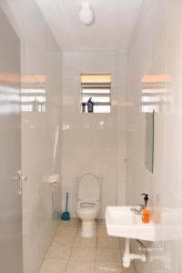 Baño blanco con aseo y lavamanos en Classic beautiful 2-Bedroom Apartment in Thika, en Thika