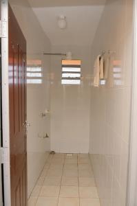 baño con ducha a ras de suelo y puerta de cristal en Classic beautiful 2-Bedroom Apartment in Thika, en Thika