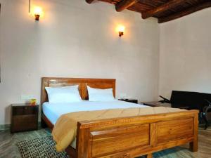 a bedroom with a large wooden bed with white pillows at Sadhna Sadan stay mountain and river view Panna tiger reserve in Rājgarh