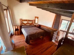 ein Schlafzimmer mit einem Bett und einem Kamin in der Unterkunft DNellys/Pinguica 1 in Mazamitla