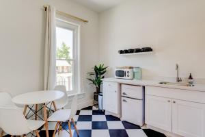 uma cozinha com armários brancos e uma mesa e cadeiras em Suite 1 Historic Art City Inn em Springville