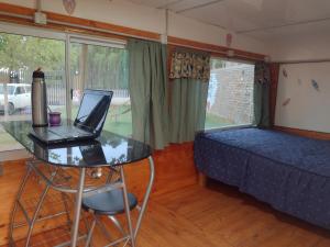 a bedroom with a laptop on a table and a bed at DORMIS P/2 in Ciudad Lujan de Cuyo