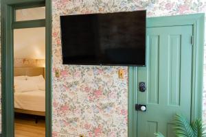 a flat screen tv on the wall of a bedroom at Suite 2 Historic Art City Inn in Springville