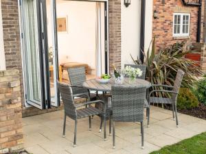 a patio table and chairs on a patio at A Wave From It All - Part of the The Bay Filey Holiday Village with pool, gym and direct beach access, pub, restaurant, tennis and meadows walks in Filey