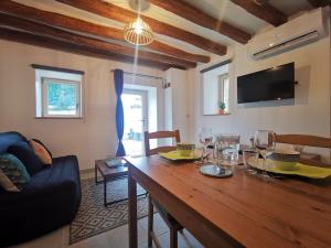 uma sala de estar com uma mesa de madeira e copos de vinho em Maison 2-3 pers semi-troglodyte Angers-Saumur em Louresse-Rochemenier