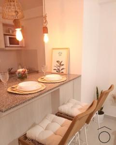 une cuisine avec un comptoir avec deux assiettes et des chaises dans l'établissement Mono Neuquen, à Neuquén