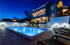 een zwembad voor een gebouw 's nachts bij Gorgeous Apartment In Jesenice With House Sea View in Jesenice