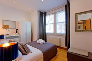 um quarto com uma cama, um espelho e uma janela em Calabria 3 - Spacious apartment em Londres