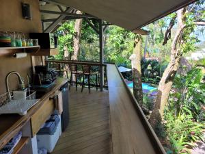 an outdoor kitchen with a deck with a tree at Treehouse La Hierba, Pavones in Pavones