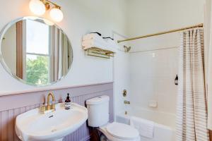 a bathroom with a sink and a toilet and a mirror at Suite 4 Historic Art City Inn in Springville