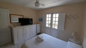 1 dormitorio con 1 cama y TV de pantalla plana en Pousada Casa da Praia Búzios, en Búzios