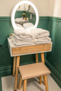 een stapel handdoeken op een tafel met een spiegel bij Suite 6 Historic Art City Inn in Springville