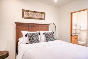 a bedroom with a bed with white sheets and pillows at El Corazon #30 in Santa Fe