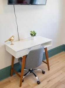 un escritorio blanco con una silla y una planta en Suite 8 Historic Art City Inn, en Springville