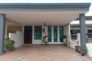 um alpendre frontal de uma casa com persianas verdes em Sweet 3 bedroom home @ Canning Garden, Ipoh em Ipoh