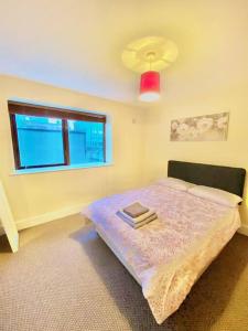 ダブリンにある2 bed Apartment in City Centreのベッドルーム1室(赤い照明と窓付)