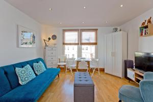 a living room with a blue couch and a table at Convenient 1 bedroom apartment with parking in London