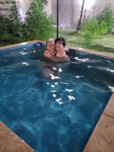 Dos niños están nadando en una piscina en La casa de los murales en Avellaneda
