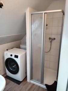 Waschmaschine und Trockner im Bad mit Waschmaschine in der Unterkunft Flensburg Zentrum 10 HH DGR in Flensburg
