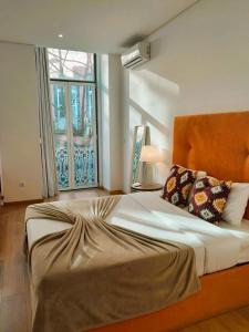 a large bed in a room with a window at Asgard Oporto Downtown Apartments in Porto