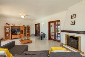 a living room with a couch and a fireplace at Vila Céu Guesthouse in Odiáxere