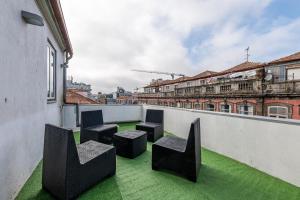 een balkon met stoelen en groen gras op een gebouw bij Asgard Oporto Downtown Apartments in Porto