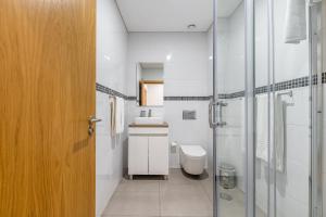 een badkamer met een toilet, een wastafel en een douche bij Asgard Oporto Downtown Apartments in Porto