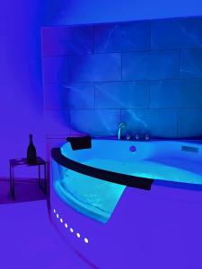 ein blaues Zimmer mit einer Badewanne und einem Tisch in der Unterkunft Modern SPA - Cosy & Chic - JACCUZI in Brunoy