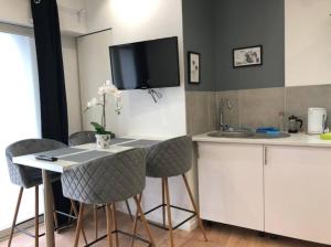 a kitchen with a table with chairs and a tv on the wall at Atelier Kersauson in Brest