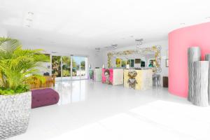 女人島的住宿－女人島米婭礁坎昆度假酒店，一间设有粉色和紫色家具和镜子的客房