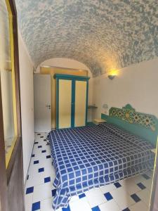 a bedroom with a blue bed in a room at Dammuso Sul mare MDQ Sea in Pantelleria