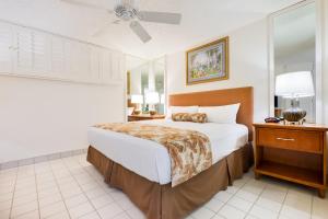 ein Schlafzimmer mit einem großen Bett und einem Deckenventilator in der Unterkunft Maui Schooner Resort in Kihei