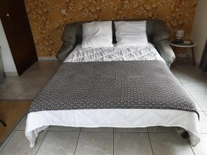 a bed with a black and white comforter and pillows at rêvedelac meublé tout confort in Brêmes