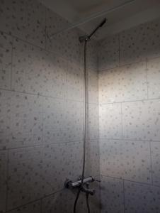 y baño con ducha y pared de azulejos blancos. en ABBA Departamento turistico en Trevelín