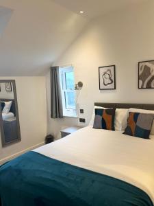 um quarto com uma grande cama branca e uma janela em Terrace House em Leamington Spa