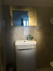 a bathroom with a white sink and a mirror at Terrace House in Leamington Spa