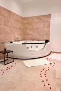 a bath tub in a room with red hearts on the floor at Modern SPA - Cosy & Chic - JACCUZI in Brunoy