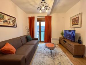 a living room with a couch and a flat screen tv at Mima Apartment in Kolašin