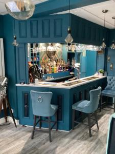 a blue kitchen with blue chairs and a bar at By the Seaside in Blackpool