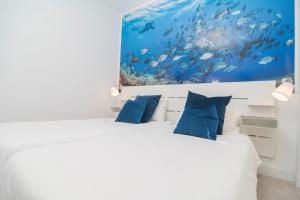 a bedroom with a bed with a painting on the wall at Marinero in La Restinga