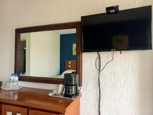 a flat screen tv on a wall next to a mirror at HOTEL TORRE MARINA in Monte Gordo