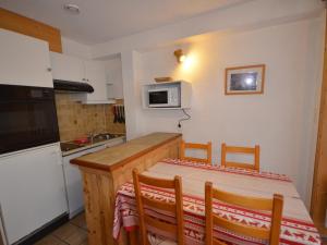 eine kleine Küche mit einem Tisch und einer Mikrowelle in der Unterkunft Studio Les Gets, 1 pièce, 4 personnes - FR-1-623-257 in Les Gets