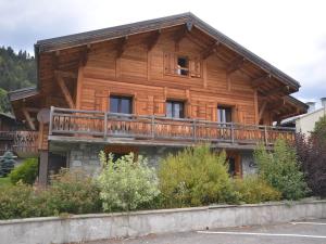 ein Holzhaus mit Balkon oben in der Unterkunft Studio Les Gets, 1 pièce, 4 personnes - FR-1-623-257 in Les Gets