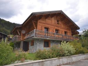 ein großes Holzhaus mit Balkon in der Unterkunft Studio Les Gets, 1 pièce, 4 personnes - FR-1-623-257 in Les Gets