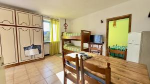 una cucina e un soggiorno con tavolo e frigorifero di Ca' del Bosco ad Alassio
