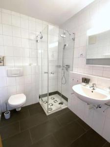 uma casa de banho com um chuveiro, um lavatório e um WC. em Fanzögna 25 em Celerina