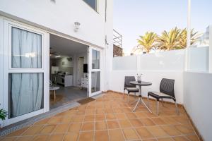 a balcony of a house with a table and chairs at Apartamento Alisios Beach Puerto del Carmen in Puerto del Carmen