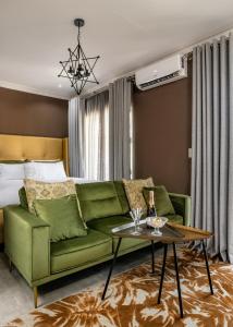 a living room with a green couch and a table at Woman Era Guest House in Midrand