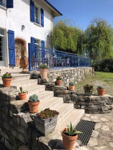 maison Laratger في Narrosse: مجموعة من السلالم أمام منزل به نباتات الفخار