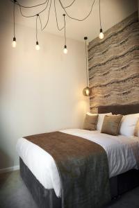 a bedroom with a large bed with a stone wall at Home @ 2 Tancred Road in Liverpool
